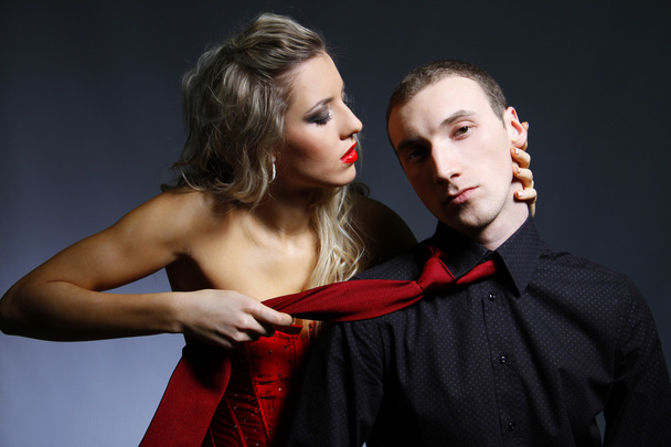 Woman holding a man for a tie - Valokuva, kuva
