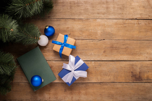 Gifts and Christmas decorations under the Christmas tree on a wooden background. Banner. Flat lay, top view. - 写真・画像