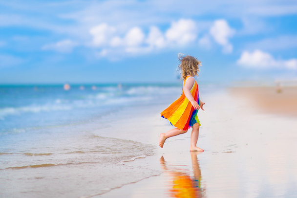 Little girl running on a beach - Valokuva, kuva