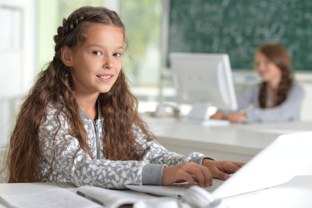 χαρούμενο κορίτσι που σπουδάζει με φορητό υπολογιστή στην αίθουσα διδασκαλίας  - Φωτογραφία, εικόνα