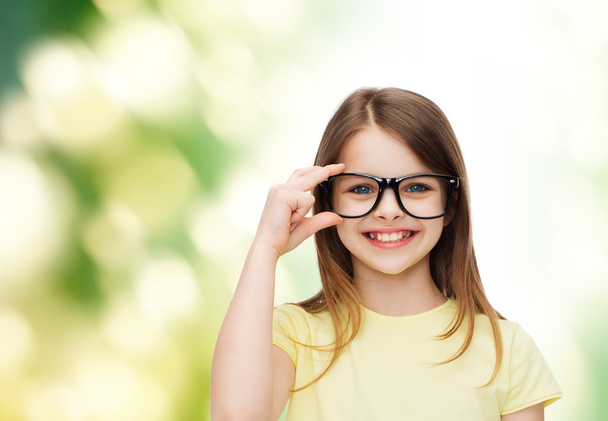 smiling cute little girl in black eyeglasses - Valokuva, kuva