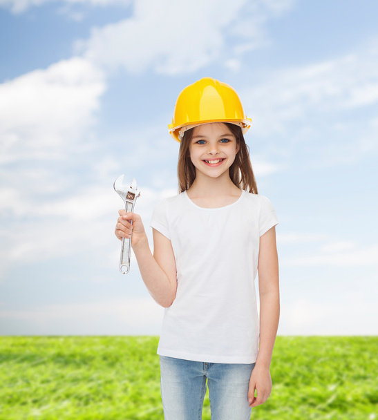 smiling little girl in hardhat with wrench - Fotografie, Obrázek