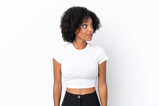 Jeune femme afro-américaine isolée sur fond blanc faisant des doutes geste regarder côté - Photo, image