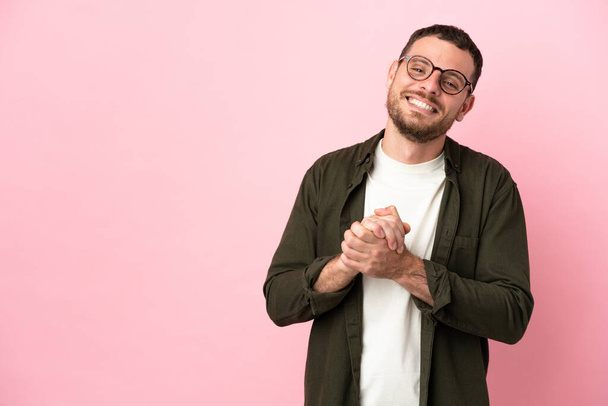 Молодой бразилец на розовом фоне смеется - Фото, изображение