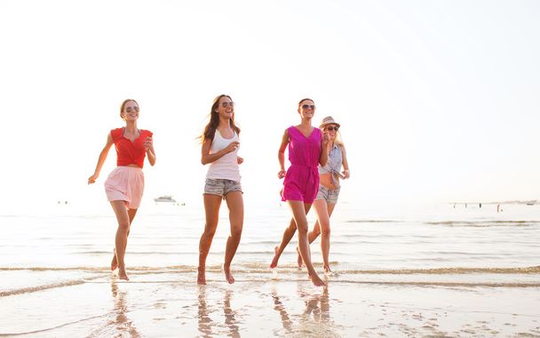 group of smiling women running on beach - Fotografie, Obrázek