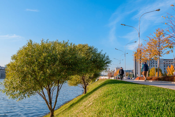 Kazan, Venäjä - 14. lokakuuta 2020: Jalankulkijoiden polku jyrkkää rantaa pitkin kaupungin järven siististi leikatulla ruoholla aurinkoisena syyspäivänä. - Valokuva, kuva