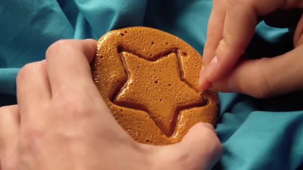 Erkek eli, yıldız şeklinde metal iğne desenli kahverengi şeker şekerini çizer - Video, Çekim
