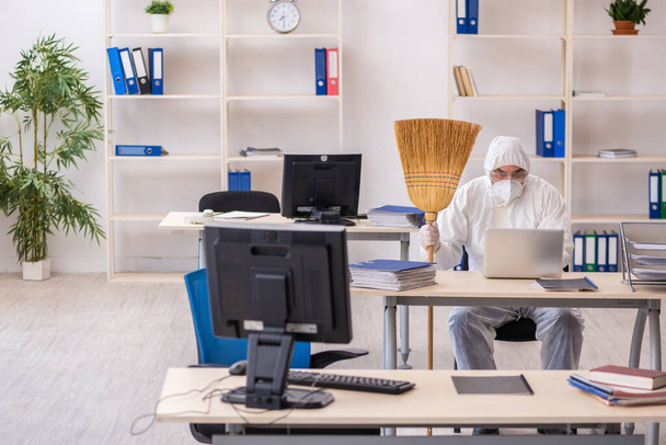 Egy öreg férfi takarítja az irodát seprűvel - Fotó, kép