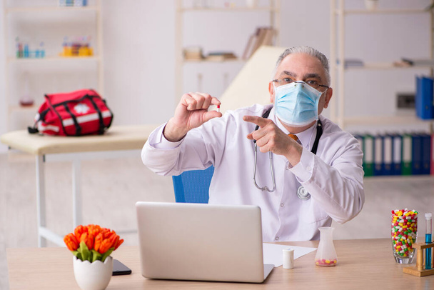 Starý lékař pracuje na klinice během pandemie - Fotografie, Obrázek