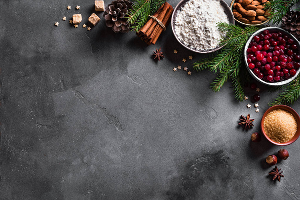 Christmas baking background with cranberris, nuts, food ingredients and seasonal spices, copy space. Cooking festive Christmas cookies for winter holidays. - Photo, Image