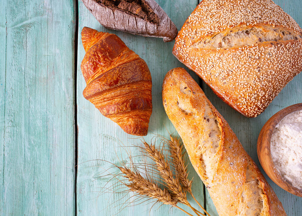 assortment of bread on turquoise wooden surface - Foto, afbeelding