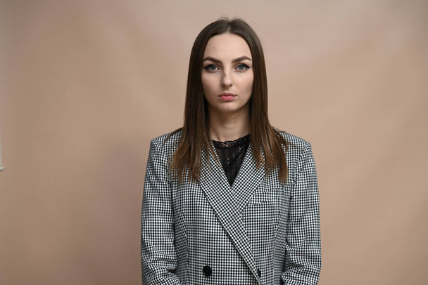 Young pretty serious woman in gray jacket with dark hair - Valokuva, kuva
