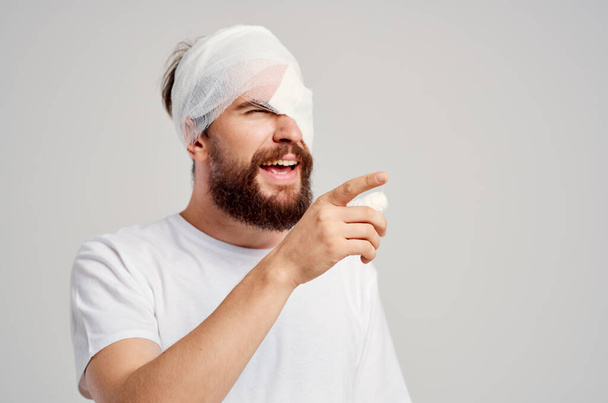 Бородатий чоловік травмує голову в білій футболці головний біль лікарняної медицини
 - Фото, зображення