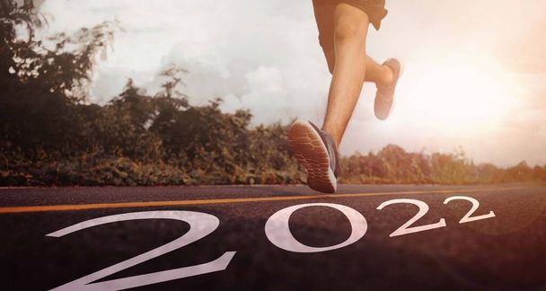 Gros plan des pieds de coureur en baskets au début de la nouvelle année, la vision et les nouvelles idées commencent en 2022. Concept d'entrer dans les objectifs et d'adopter pour le succès en 2022. - Photo, image