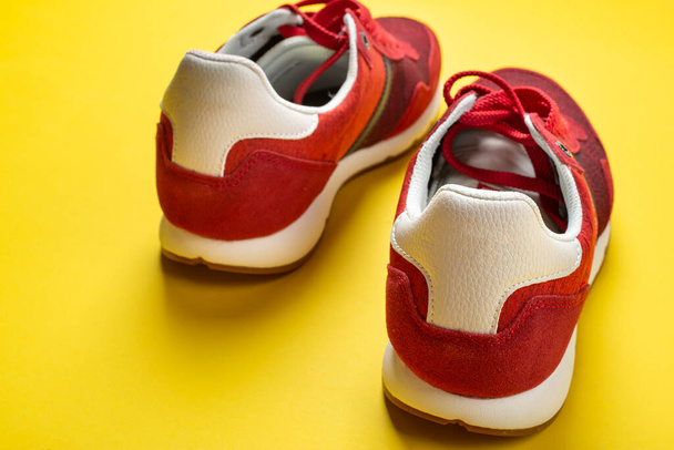 New red sneakers on a yellow background. space for text. Pair of sport shoes. - Fotoğraf, Görsel