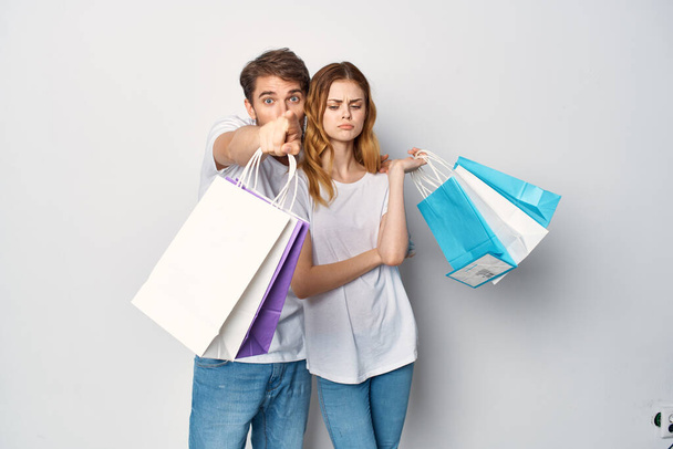 man en vrouw met pakketten in handen winkelen emoties - Foto, afbeelding