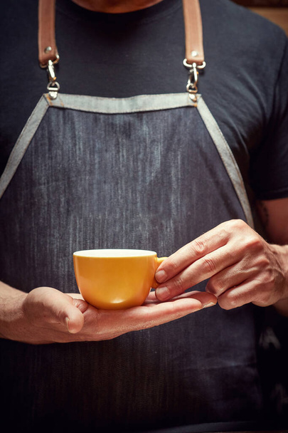 Barista holding and serving cup of fresh dark coffee - Fotoğraf, Görsel