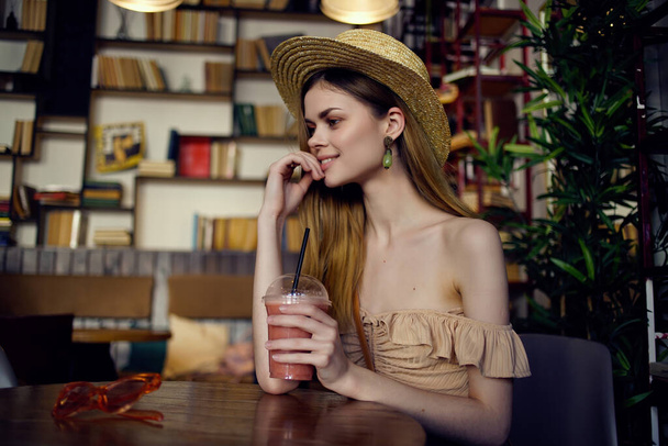 όμορφη γυναίκα διαβάζει ένα βιβλίο σε μια καφετέρια αναψυχής - Φωτογραφία, εικόνα