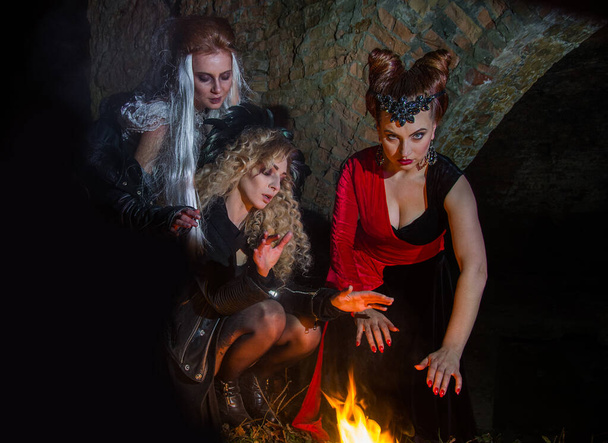 Čarodějky zaklínají u ohně o Halloweenské noci. Duchovní dívky. - Fotografie, Obrázek