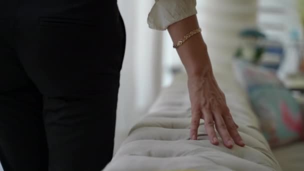 mujer corre su mano en el sofá - Imágenes, Vídeo