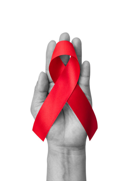 Světová pomoc den a národní HIV AIDS a stárnutí měsíc s červenou stuhou na pomocnou ruku (izolované s výstřižkem stezka na bílém pozadí)  - Fotografie, Obrázek