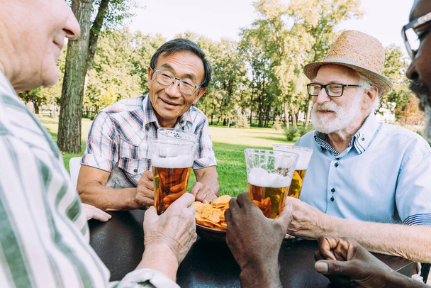 group of senior friends drinking a beer at the park. Lifestyle concepts about seniority and third age - Valokuva, kuva