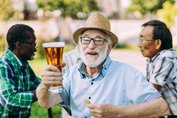 grupo de amigos mayores bebiendo una cerveza en el parque. Conceptos de estilo de vida sobre la antigüedad y la tercera edad - Foto, Imagen