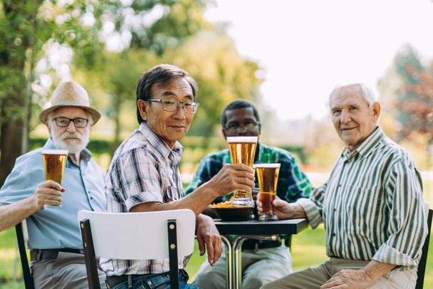 group of senior friends drinking a beer at the park. Lifestyle concepts about seniority and third age - Фото, зображення