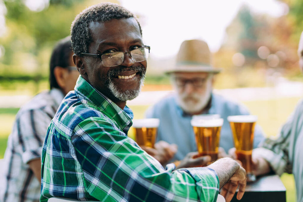 group of senior friends drinking a beer at the park. Lifestyle concepts about seniority and third age - Fotó, kép