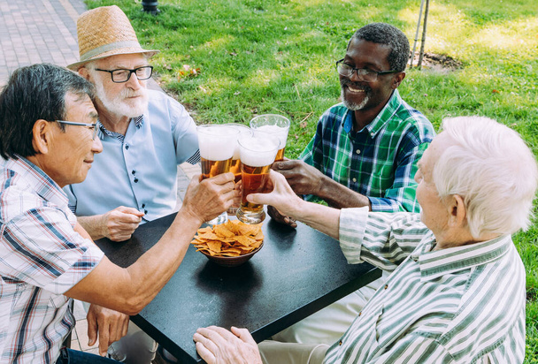 group of senior friends drinking a beer at the park. Lifestyle concepts about seniority and third age - Fotó, kép