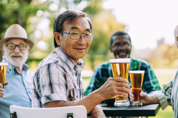group of senior friends drinking a beer at the park. Lifestyle concepts about seniority and third age - Photo, Image
