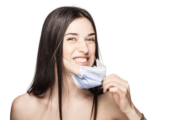 Angry girl pulling away medical face mask. Portrait against white background. - Фото, зображення