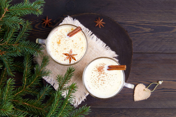 Eggnog Christmas drink. Milk cocktail with grated nutmeg and cinnamon for Christmas and winter holidays, top view. High quality photo - Foto, imagen