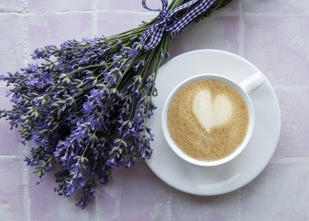 Kuppi kahvia laventeli maustettu macaroon jälkiruoka vaaleanpunainen laatat tausta - Valokuva, kuva