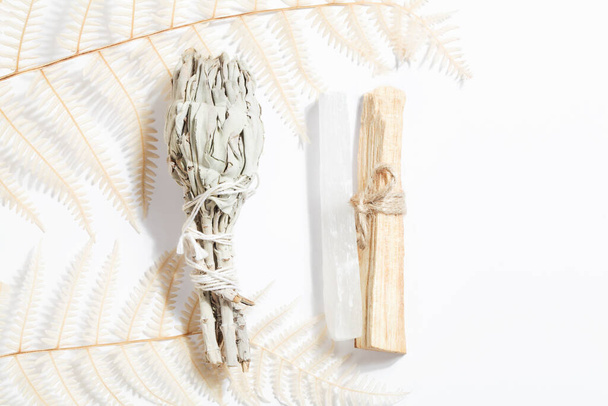 Пало Санто придерживается селенит, высушенный шалфей и папоротник, волшебный камень для ритуала, колдовства, духовной практики, медитации. концепция эзотерического баланса жизни - Фото, изображение