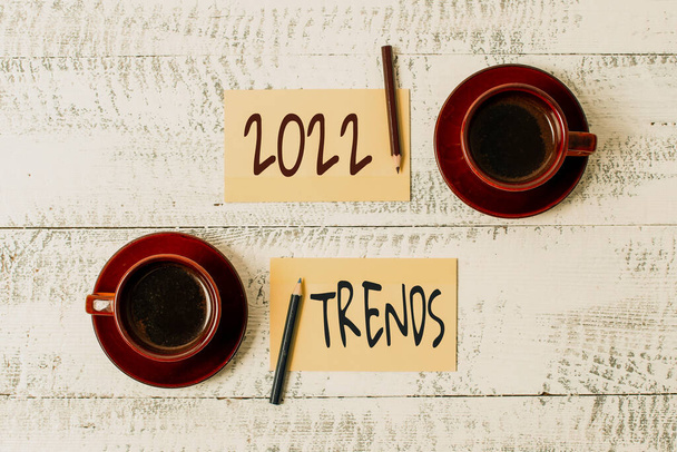 Bildunterschrift: Die Trends für 2022. Geschäftskonzept allgemeine Richtung, in die sich etwas entwickelt oder ändert Anzeige von Aufklebern unterschiedlicher Farbe auf flachem Hintergrund angeordnet - Foto, Bild