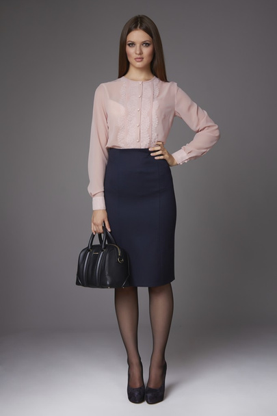 Beautiful sexy young business woman with evening make-up wearing a skirt to the knee and a silk blouse with lace long sleeves and high-heeled shoes, business clothes for meetings and walks - Foto, immagini