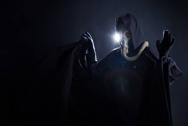 post-apocalyptic character, a scary story, a concept character in a gas mask and a black coat - Foto, imagen