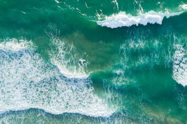Deniz dokusunun en üst görüntüsü dalgalar köpürerek ve su sıçratarak okyanus güneşli bir günde güzel bir deniz yüzeyi arka planında. - Fotoğraf, Görsel