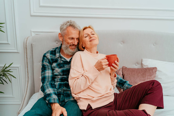 husband and wife have breakfast with coffee on the bed at home - Photo, Image