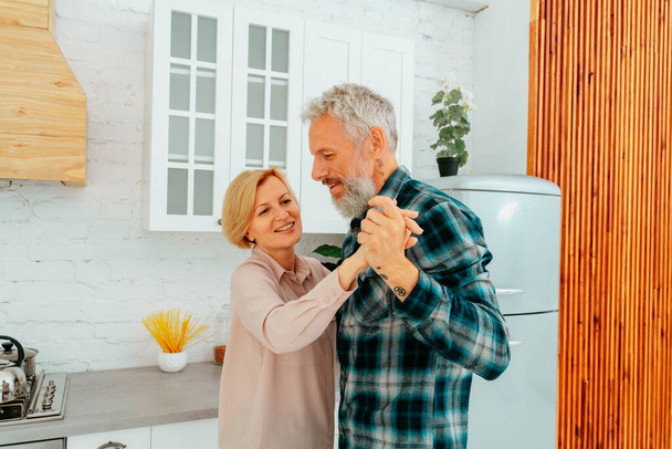 муж и жена танцуют дома во время завтрака - Фото, изображение