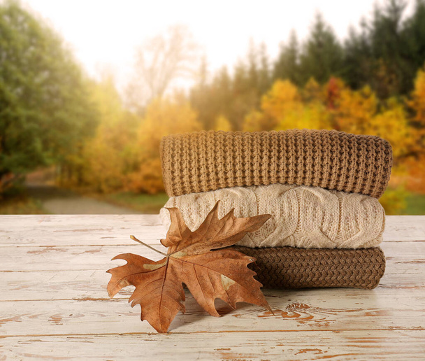 Stylish autumn clothes on table in autumn park - Photo, Image