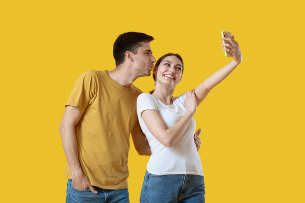 Nuori pari ottaa selfie keltaisella taustalla - Valokuva, kuva