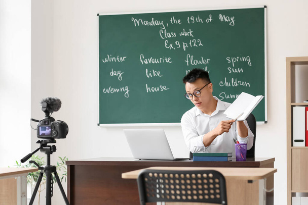 Учитель азиатского языка проводит урок английского языка онлайн - Фото, изображение