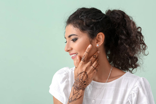 Piękna Hinduska kobieta z tatuażem henny na tle koloru - Zdjęcie, obraz
