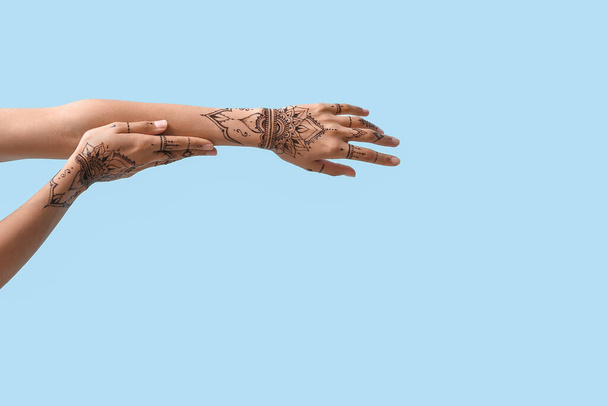 Женские руки с татуировкой хны на цветном фоне - Фото, изображение