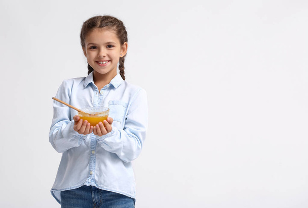 Κοριτσάκι με μέλι σε λευκό φόντο - Φωτογραφία, εικόνα