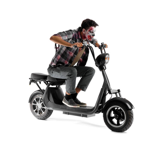Man dressed for Halloween as zombie with motorcycle on white background - Foto, afbeelding