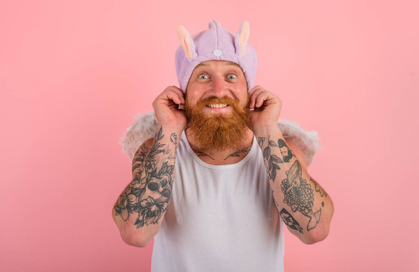 Happy man with beard and tattoos acts like an angel - Photo, Image