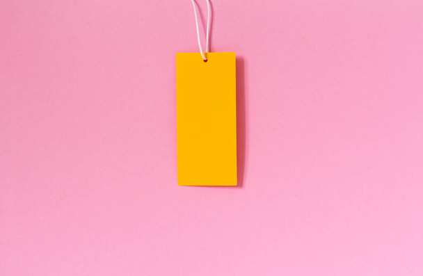 Mock up χαρτόνι κενό ετικέτα με θέση για κείμενο σε ροζ φόντο. Έννοια πώλησης - Φωτογραφία, εικόνα